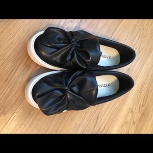 Black tied bow faux leather slip on
